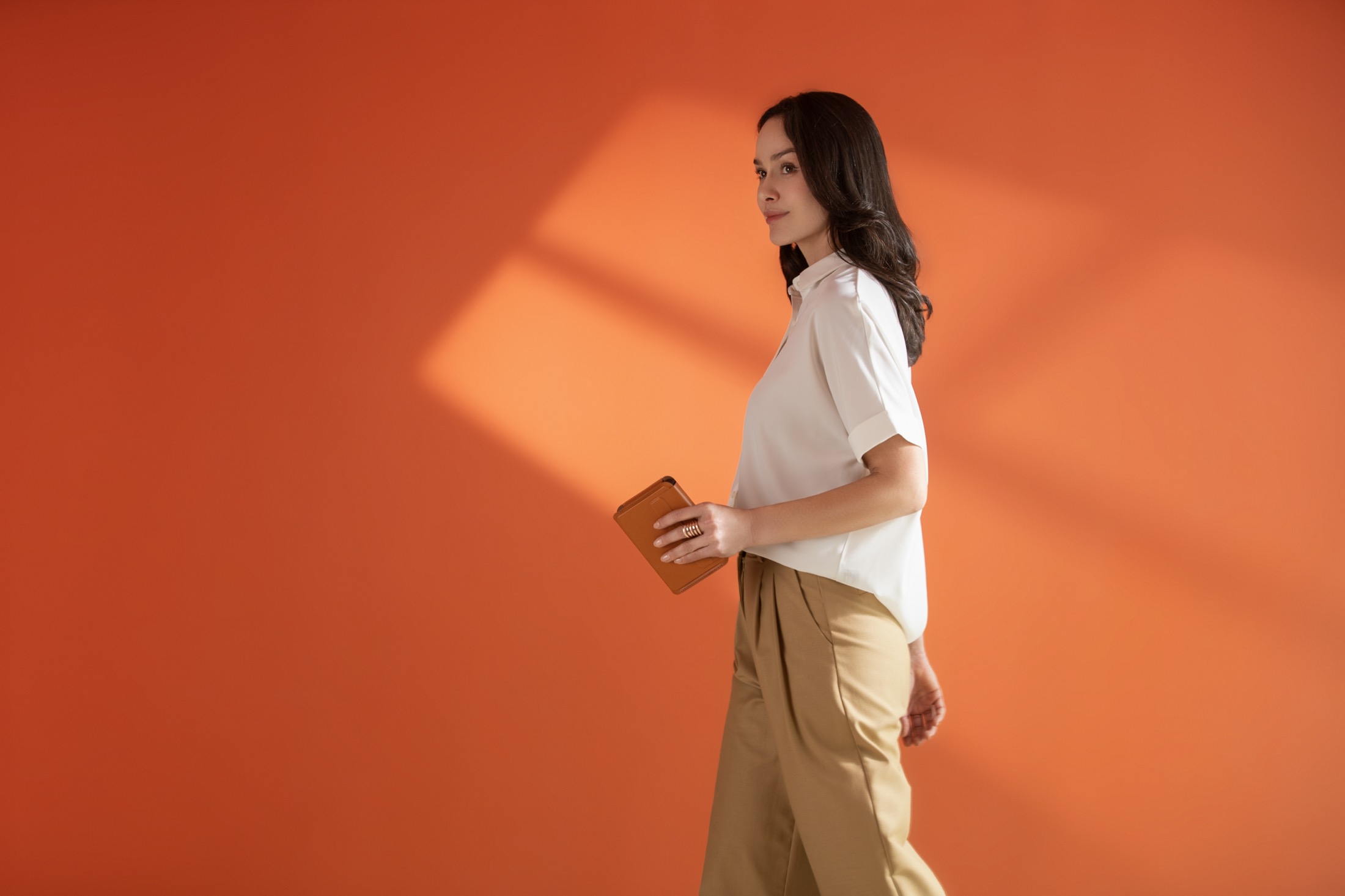 A woman walking with the Khadas Mind held in one hand, like a notebook